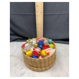 box of assorted christmas ornaments in woven basket
