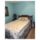 Wooden spindle bed frame with mattress and bedding