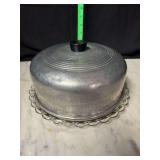 Vintage aluminum cake topper on glass cake plate