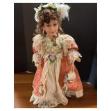 Vintage porcelain doll on stand
