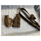 Two gun holsters and a shoulder strap