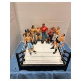 Assorted wrestling figurines in toy wrestling ring