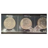 Three Kennedy Half Dollar Coins in Holders