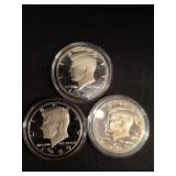 Three Kennedy Half Dollar Coins in Cases