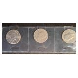 Three Kennedy Half Dollar Coins in Holders