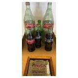 Coca-Cola Bottles with Framed Advertising Display