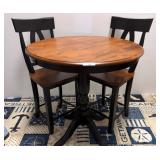 Round Wood Table with Two Black-Framed Chairs