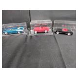 Three Diecast Model Cars in Display Cases