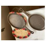 2 cast iron skillets with tivets