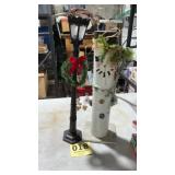 Wooden snowman and street light pole