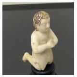 Carved ivory figure kneeling on pedestal