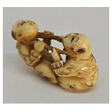 Netsuke- Carved ivory two children rocking, signed