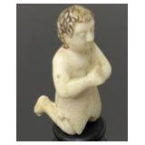 Carved ivory figure kneeling on pedestal