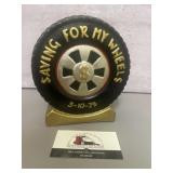 Decorative tire-shaped piggy bank featuring gold