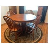 Kitchen table and chairs with rug.