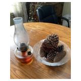 Oil lamp and dish of pinecones