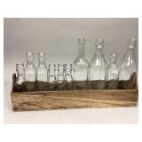 Wooden planter box with assorted glass bottles