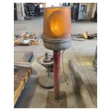 Yellow hazard light on metal base.