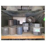 Shelf of black pipe fittings.