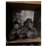 Cubby of black pipe fittings