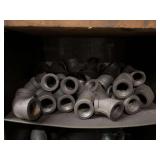 Cubby of black pipe fittings