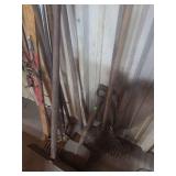 lot containing 2 rakes, 2 shovels, a hoe, and a pair of snow skis
