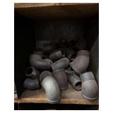 Cubby of black pipe fittings