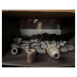 Cubby of black pipe fittings