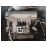 vintage V8 engine intake manifold with a four-barrel carburetor mounting plate, likely from a 1950s or 1960s American