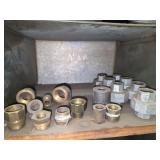 Shelf of brass and galvanized pipe fittings.