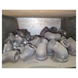 Shelf of black pipe fittings.