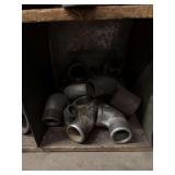 Cubby of black pipe fittings