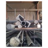 contents of shelf.  several pieces of  angled,  solid round and square and hexagon steel. sizes range from rements to 15 feet