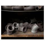 Cubby of black pipe fittings