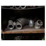 Cubby of black pipe fittings
