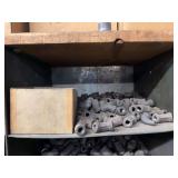 Cubby of black pipe fittings