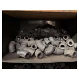 Cubby of black pipe fittings