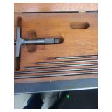 lot contains a  depth micrometer set in a wooden box. typically used by machinists to precisely measure the depth of holes, slots, recesses, and other features.