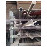 contents of shelf.  several pieces of angled aluminum and solid round steel rods ranging in length from 4ft to 20 ft.