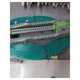 lot. contains a Expert Gardener brand oscillating lawn sprinkler along with 2 25ft sections of flat watering hose.