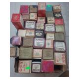 lot contains a box of  player piano rolls. These are vintage music storage media, primarily consisting of rolls of paper with perforated holes that represent musical notes, used to operate automatic p