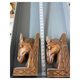 Two wooden horse head decor.