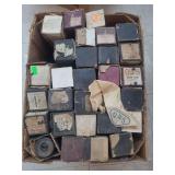 lot contains a  box of  player piano rolls. These are vintage music storage media, primarily consisting of rolls of paper with perforated holes that represent musical notes, used to operate automatic 