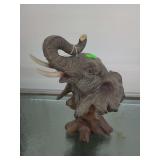 lot contains an elephant bust statue from the Herco Reverie Collection, designed with a faux wood or resin finish.  elephant is 11 in tall . PY-265e