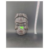 lot contains a  hand-carved wooden mask, often found in various traditional or folk art collections.