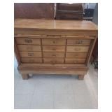 lot contains a vintage oak cabinet featuring a tambour door, a type of flexible sliding door constructed from narrow wooden slats that roll into the cabinet's frame. inside there are 12 drawers for fi