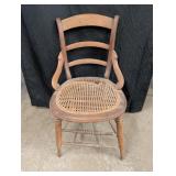 Ant. Wood ladder back arm chair w/ cane seat