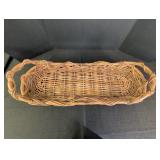 Long wicker basket w/ handles used for decorating
