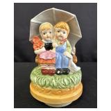 Porcelain music box w/ a boy & girl under umbrella