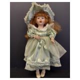 23in porcelain doll, unmarked.  Green dress & hat,